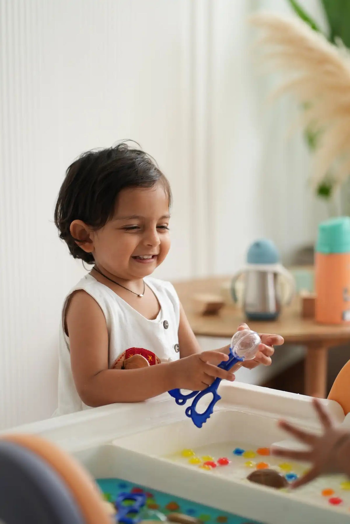 A cheerful child playing with a blue bubble wand.