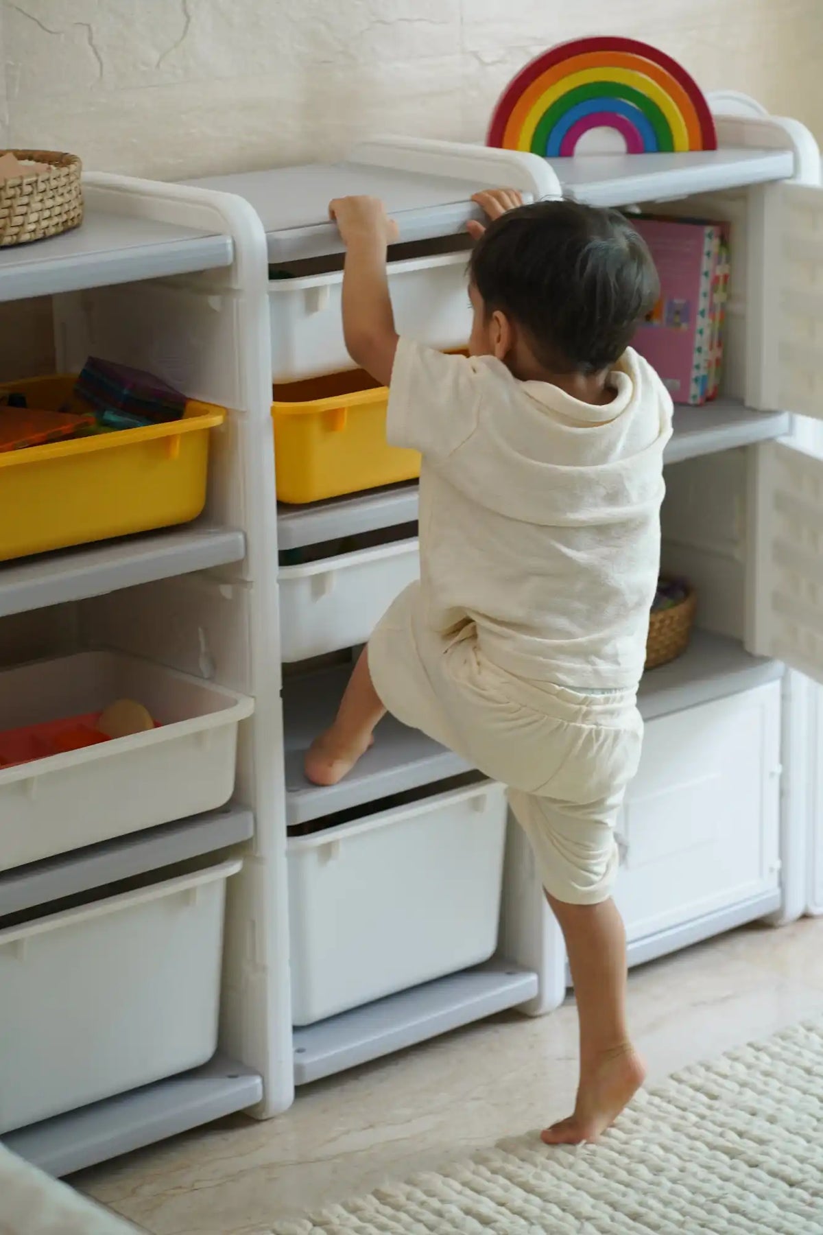 A child’s storage unit with open shelves and pull-out bins.