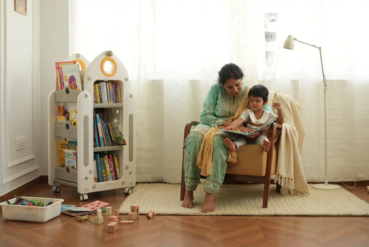A white and yellow plastic children’s bookshelf on wheels.