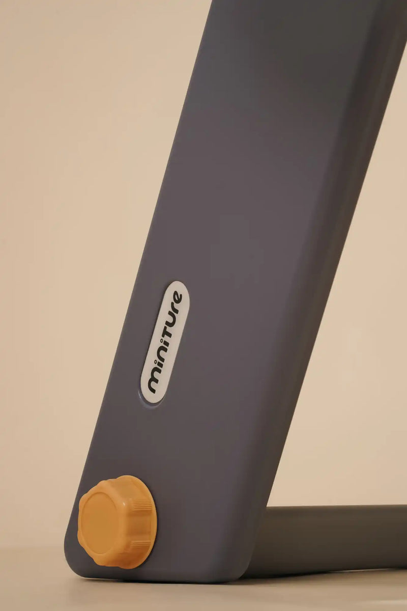 A foldable, dark gray mobility aid with an orange adjustment knob.