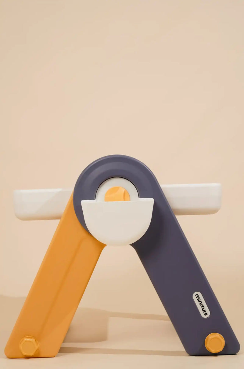 A foldable egg slicer with a white center and orange and purple arms.