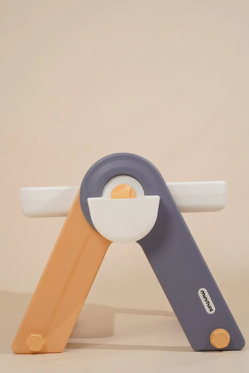 A two-toned, foldable plastic stand with a central bowl and two side arms.